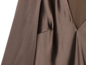 Detail eines eleganten braunen Satinkleids mit V-Ausschnitt und seidiger Stoffstruktur