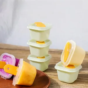 Close-up of DIY popsicle molds with lids and sticks on a rustic wooden table