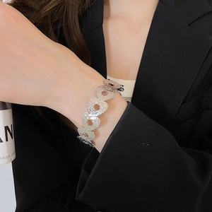 Detail of silver layered hollow open cuff bracelet with hammered texture on a model