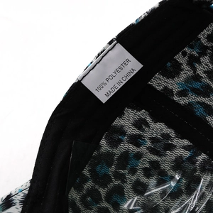 Close-up of the leopard print baseball cap inner lining and 100% polyester care label