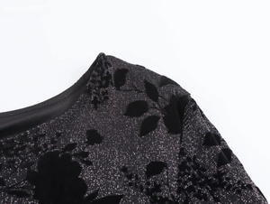 Detail of black metallic fabric with textured floral flocking and round neck collar
