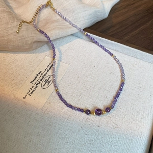 Detail of purple gradient beaded necklace with gold spacers and adjustable lobster clasp