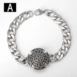 Detail of silver Viking Celtic cross emblem on chunky stainless steel Cuban chain bracelet