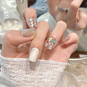 Sparkling cat-eye press-on nails in translucent white and nude with colorful rhinestone accents