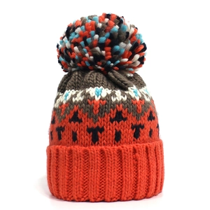 Orangefarbene Strickmütze mit geometrischem Muster und buntem Bommel auf weißem Grund