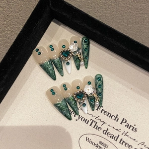 Emerald green press-on nails with marble texture, 3D floral accents and heart gems