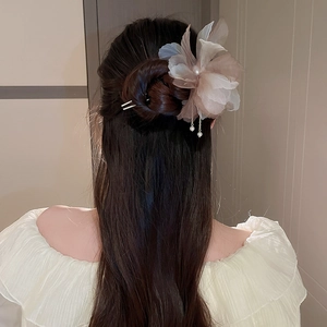 Détail de l'épingle à cheveux en organza champagne avec pompons de perles sur chignon