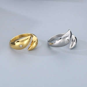 Detailed close-up of 18k gold and silver dolphin teardrop rings with cubic zirconia