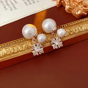 Luxurious gold flower earrings with zircon inlays and large pearls on vintage frame