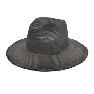 Détail d'un chapeau Panama en paille noire avec texture tissée, bord effiloché et ruban