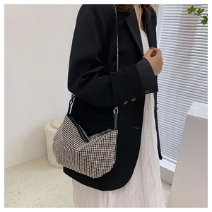 Silver rhinestone shoulder bag with metal chain strap shown on a black blazer outfit