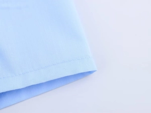 Gros plan sur la texture du tissu bleu clair avec coutures précises et finitions soignées