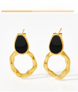 Detailed close-up of vintage gold wavy hoop earrings with black enamel inlay