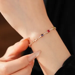 Vintage gold bracelet with multi-colored circular gemstones on a model wrist