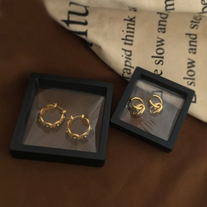 Detail showing vintage gold earrings displayed in a black 3D floating jewelry storage box