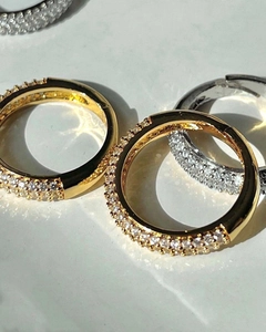 Macro shot of 18k gold and silver micro-pave zircon hoop earrings on marble background