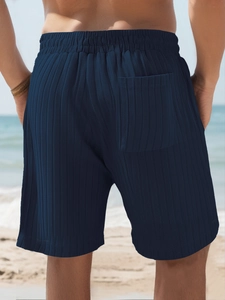 Detail view of navy blue striped men's beach shorts with textured knit fabric and rear pocket