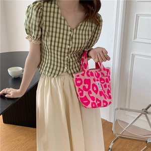 Close-up of pink leopard print canvas tote bag with sturdy handles and white label