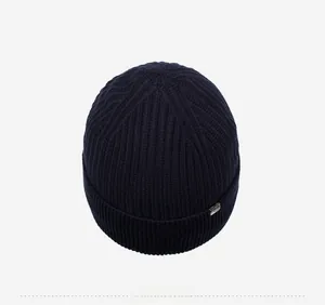 Top view of thick dark blue ribbed knit beanie with small decorative metal tag