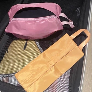 Waterproof travel organizer set including pink laundry bag and orange shoe pouch for suitcase