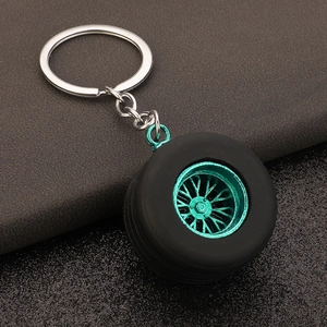Macro detail of PVC tire keychain with cyan metal rim and textured rubber tread