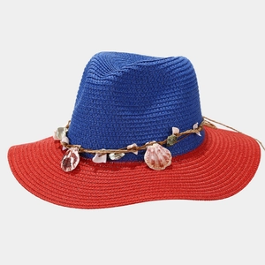 Detail of blue and red straw hat featuring natural sea shells and braided rope trim