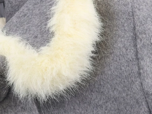 Close-up of faux fur trim and grey wool blend fabric on the stylish jacket set