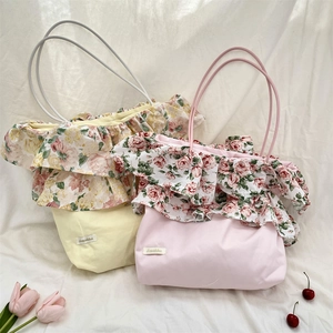 Dettaglio della borsa tote in tela con volant floreali, rose retrò ed etichetta tessuta