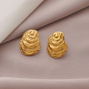 Golden C-shaped sunflower spiral earrings with pearl and hammered texture detail