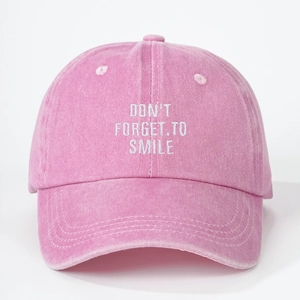 Detail der Stickerei DON'T FORGET TO SMILE auf einer gewaschenen rosa Baseballkappe
