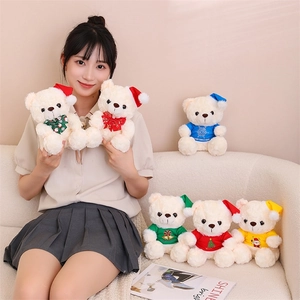 Group of six beige teddy bears wearing festive Christmas hats and colorful holiday t-shirts