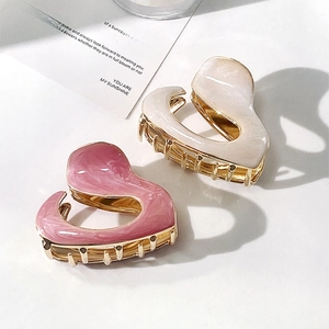 Elegant heart-shaped hair claws in pink and pearl white with gold metal base