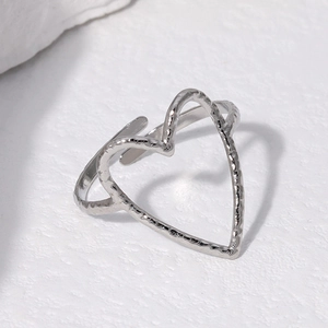 Detailed view of silver heart-shaped open ring featuring unique hammered texture finish
