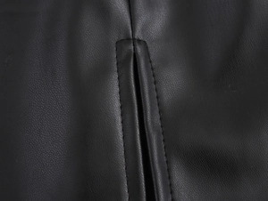 Macro shot of faux leather texture and precise stitching on the pocket of a PU mini dress