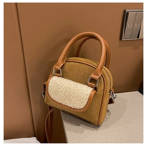 Detail of caramel suede handbag with cream fleece pocket and silver zipper hardware
