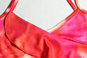 Macro view of colorful tie-dye print and stitching details on a sexy backless dress