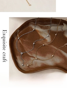 Detailed close-up of gold and silver flower Y-shaped necklaces with zircon inlays