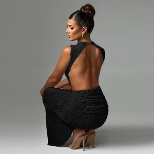 Detail shot of black backless maxi dress featuring pleated texture and side slit design