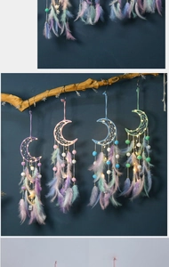 Detail of moon-shaped dreamcatchers with colorful feathers and warm LED fairy lights