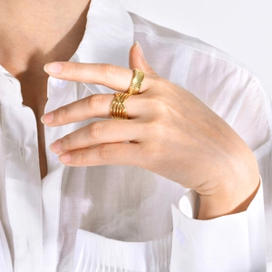 Close-up of gold-plated textured and multi-layer cross rings on a model's hand
