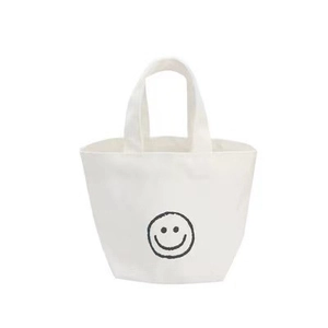 Minimalist creamy white canvas tote bag featuring a black hand-drawn smiley face graphic