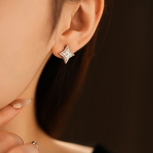 Gros plan d'une boucle d'oreille étoile en zircon brillant portée par un mannequin