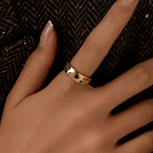 Vintage wide gold ring featuring colorful gemstones and star carvings worn on hand
