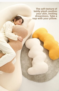 Cozy teddy velvet flower pillow in a wave shape shown in a comfortable home setting