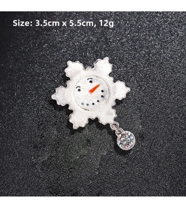Detail view of snowflake brooch with snowman face and colorful rhinestone pendant, 3.5cm x 5.5cm