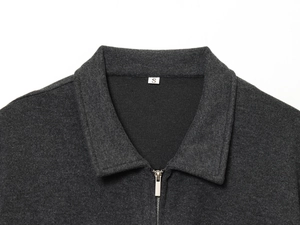 Detailaufnahme des dunkelgrauen Strickjackenkragens mit Metallreißverschluss und Stoffstruktur