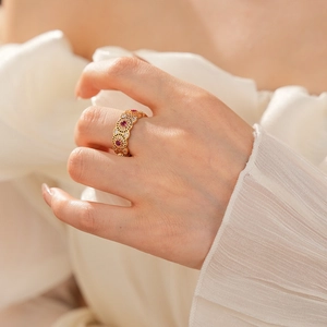 Dettaglio anello filigrana placcato oro 18k con gemme rosse su dito indice