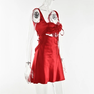 Close-up of red silk mini dress featuring pleated chest ties and side waist cutouts