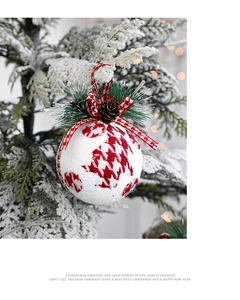 Detail of a white frosted Christmas ball with red houndstooth and pine cone decor