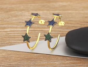 Detail of 18k gold plated C-shape hoop earrings with colorful zircon star charms